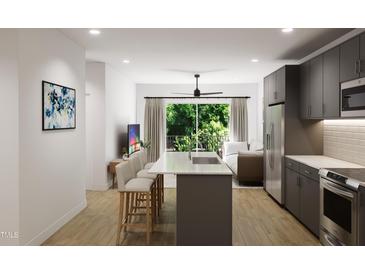 Modern kitchen with island, stainless steel appliances, and gray cabinetry at 711 E Lenoir St # 207, Raleigh, NC 27601