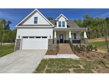 Charming new construction home featuring white siding, stone accents, and an inviting front porch at 1116 Prominence Dr., Homesite 31, Durham, NC 27712
