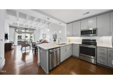 Bright kitchen boasts stainless appliances, quartz countertops, and an island with pendant lighting at 1300 St Marys St # 403, Raleigh, NC 27605