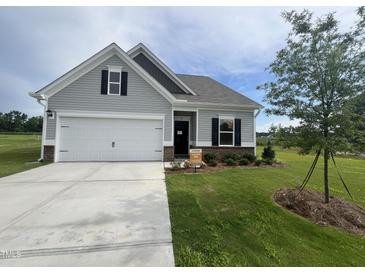 Charming one-story home with a well-manicured lawn and a two-car garage at 14 E American Marigold Dr # 65, Benson, NC 27504