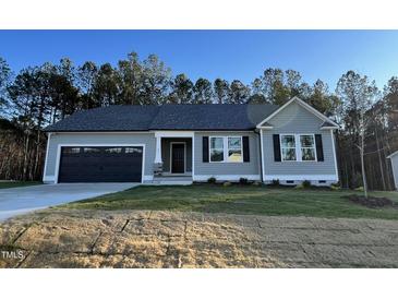 One-story house with gray siding, black shutters, and a two-car garage at 257 Magnolia Run Way, Benson, NC 27504