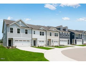 New townhomes featuring unique color schemes, attached garages and manicured lawns at 8703 Wardle Ct, Wake Forest, NC 27587