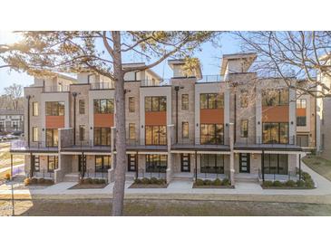 Modern three-story townhouses with balconies and neutral brick exterior at 1018 Manor Way, Durham, NC 27701
