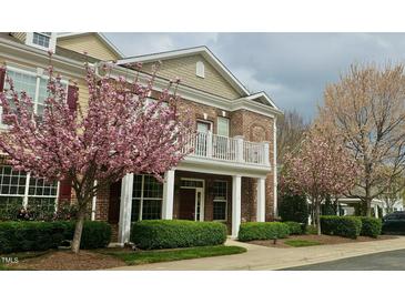 Charming two-story brick home with a balcony and flowering trees in a well-manicured front yard at 10511 Sablewood Dr # 110, Raleigh, NC 27617