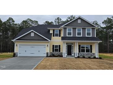Two-story house with gray and yellow siding, white garage door, and landscaping at 117 Sunburst Ct, Fuquay Varina, NC 27526
