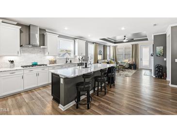 Modern kitchen with granite island, stainless steel appliances, and white cabinetry at 1626 Plover Cir, Fuquay Varina, NC 27526