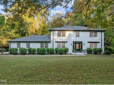 White brick house with dark trim, lush landscaping, and a spacious lawn at 2421 New Bern Ave, Raleigh, NC 27610