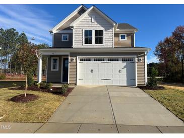 Two-story house with beige siding, white trim, and a two-car garage at 36 Railcar Way, Clayton, NC 27520