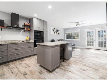 Modern kitchen with gray cabinets, granite counters, stainless steel appliances, and a central island at 4236 Lake Ridge Dr, Raleigh, NC 27604
