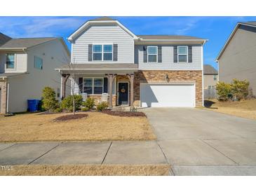 Two-story home with gray siding, stone accents, and a two-car garage at 664 Lavenham Ln, Fuquay Varina, NC 27526