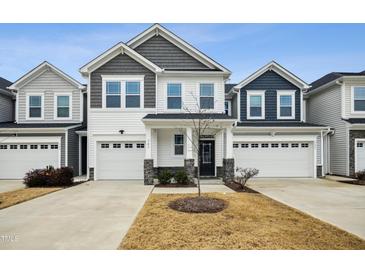 Two-story townhome with gray and white siding, two-car garage, and landscaping at 747 Creekway Dr, Fuquay Varina, NC 27526
