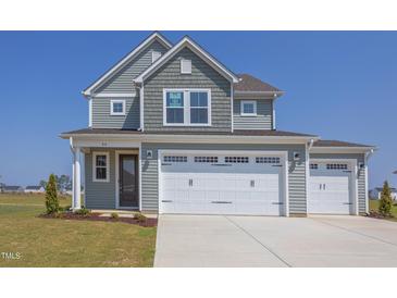 Two-story house with gray siding, white trim, and a three-car garage at 86 Barn Door Dr, Lillington, NC 27546