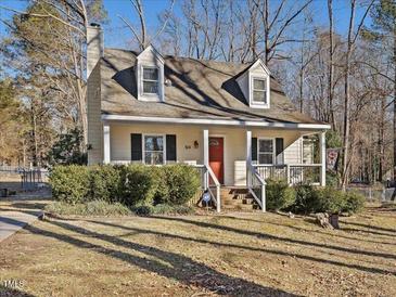 Charming one and a half story home with a chimney, dormers, black shutters, and a quaint front porch at 504 Meadow Run, Knightdale, NC 27545