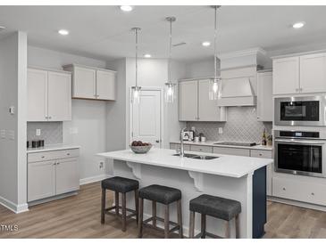 Modern kitchen with white cabinets, quartz countertops, and an island at 23 Village Edge Dr, Lillington, NC 27546