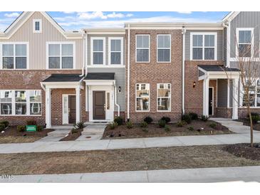 Charming brick townhomes featuring welcoming front porches and well-maintained landscaping at 277 Chesapeake Commons St # 94, Garner, NC 27529