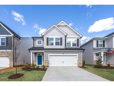Charming two-story home features a modern facade, two-car garage, and well-manicured lawn at 34 Fairwinds Dr, Lillington, NC 27546