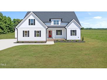 Charming new construction farmhouse with a bright red front door, black shutters, and a well-manicured lawn at 5377 River Buck Rd, Spring Hope, NC 27882