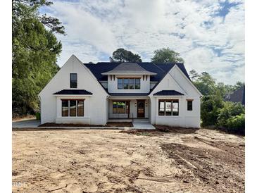 Stunning new construction, white brick home featuring black trim and dark roof at 5820 Shawood Dr, Raleigh, NC 27609