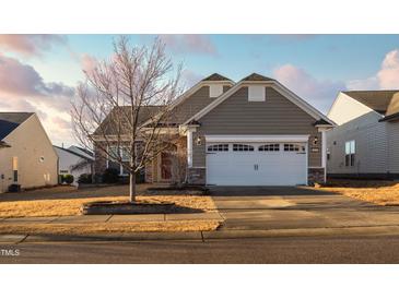 One-story home with stone accents and a two-car garage at 830 Downfield Ln, Fuquay Varina, NC 27526