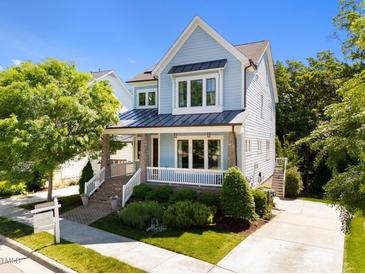 Charming two-story home with a welcoming front porch and professionally landscaped front yard at 1000 Norris St, Raleigh, NC 27604