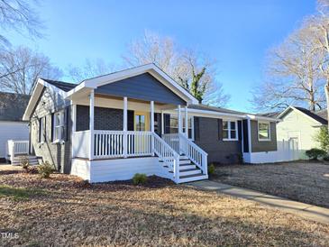 Charming ranch home with updated brick exterior, welcoming porch, and landscaped yard at 1014 E Jones St, Raleigh, NC 27601