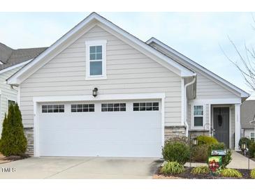 Charming home featuring a two-car garage, stone accents, neutral siding, and well-manicured landscaping at 125 Canary Ct. Ct, Raleigh, NC 27610