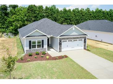 Charming single-story home featuring a stone-accented facade, a two-car garage, and a well-manicured lawn at 1701 Drayton Hall Ln, Sanford, NC 27330