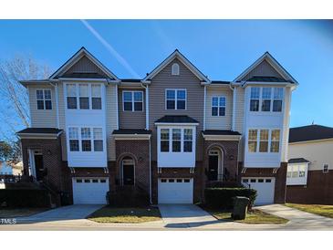 Charming townhome featuring brick facade, private garages, and covered entryways for comfortable and stylish living at 5409 Crescentview Pkwy, Raleigh, NC 27606