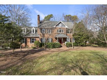 Brick two-story home with landscaped lawn and red front door at 1800 Deer Fern Dr, Raleigh, NC 27606