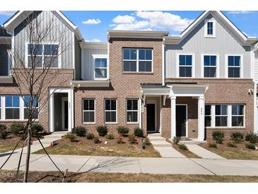 Newly constructed townhomes with a mix of brick and siding and manicured lawns at 284 Chesapeake Commons St # 150, Garner, NC 27529