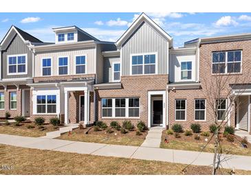 Charming townhouse with a brick facade, symmetrical windows, and manicured landscaping in a suburban neighborhood at 288 Chesapeake Commons St # 149, Garner, NC 27529