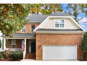 Brick two-story house with a white garage door and American flag at 3921 Robins Nest Ln, Wake Forest, NC 27587