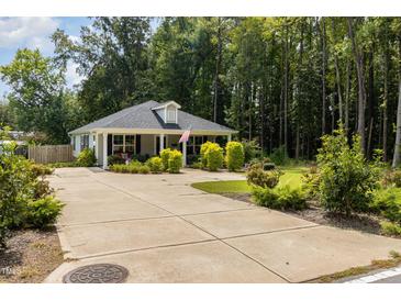 Charming one-story house with a gray exterior, landscaped yard, and a spacious driveway at 619 Barbour St, Clayton, NC 27520