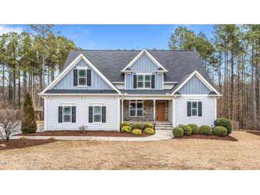 Two-story home with gray siding, gray roof, and landscaping at 1513 Hoke Landing Ln, Raleigh, NC 27603