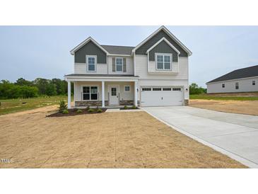 Charming two-story home featuring a covered porch and attached two-car garage at 236 Johnson Ridge Way, Four Oaks, NC 27524