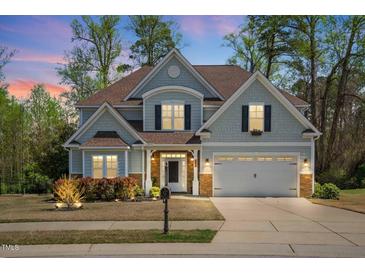 Charming two-story home with a manicured lawn, a two-car garage, and beautiful landscaping at 347 Country Mill Way, Fuquay Varina, NC 27526
