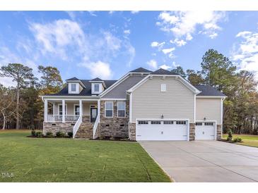 Two-story house with stone accents, three-car garage, and a landscaped lawn at 4809 Bristol Meadow Dr, Raleigh, NC 27603