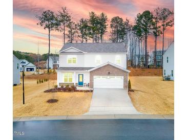 Two-story house with brick and white siding, a two-car garage, and a landscaped yard at 53 Albereto Dr, Clayton, NC 27527