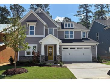 Charming two-story home with gray siding, stone accents, a yellow front door and an attached two-car garage at 9164 Dupree Meadow Dr # 14, Angier, NC 27501