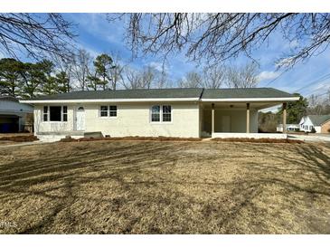 Newly renovated ranch home features a covered porch and well-manicured lawn at 209 Carolyn Dr, Benson, NC 27504