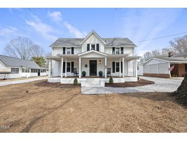 Charming two-story farmhouse-style home with a covered front porch and classic black shutters at 210 W Oak Ave, Wake Forest, NC 27587