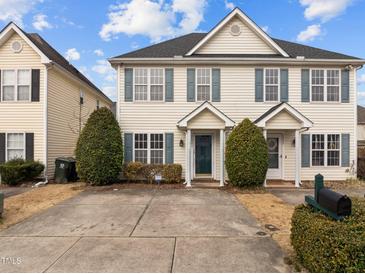 Two-story townhome with light beige siding, gray shutters, and a shared driveway at 2321 Turtle Point Dr, Raleigh, NC 27604