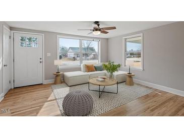 Bright living room boasts hardwood floors, natural light, and stylish contemporary furniture at 322 Pace St, Smithfield, NC 27577