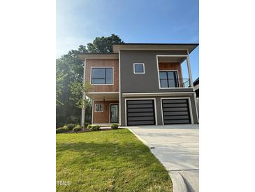 Modern two-story home with wood and gray siding, two-car garage, and well-manicured lawn at 324 Waldo St, Cary, NC 27511