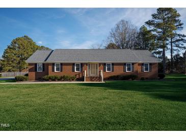 Brick ranch house with a spacious lawn and mature trees at 610 Denim Dr, Erwin, NC 28339