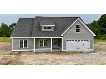 Charming gray home with a white garage door, porch, and well-manicured lawn at 6294 River Rd, Fuquay Varina, NC 27526