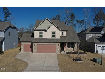 Two-story house with two-car garage, stone accents and solar panels at 897 Golden Plum Ln, Zebulon, NC 27597