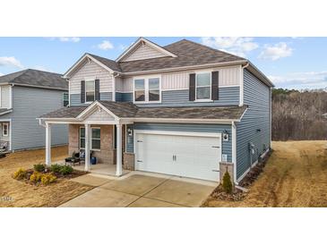 Two-story house with gray siding, brick accents, and a two-car garage at 1007 Cherry Stem Rd, Haw River, NC 27258