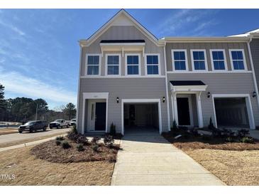 New construction townhome features a two-car garage and beautifully landscaped front yard at 103 Central Townes Way # 297, Raleigh, NC 27603