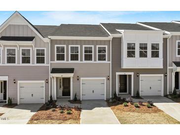 New construction townhome with front entry garages and manicured landscaping at 107 Central Townes Way # 298, Raleigh, NC 27603